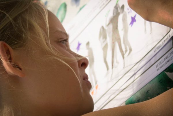 Kind bewerkt frame van pop videoclip handmatig met verf, stiften en stickers voor een kleurig stop motion animatie.