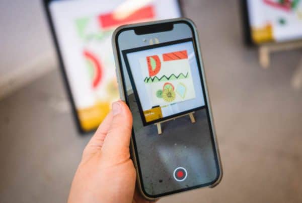 Leerling scan zijn interactieve Augmented Reality kunstwerk met de Artivive app in een digitale media workshop