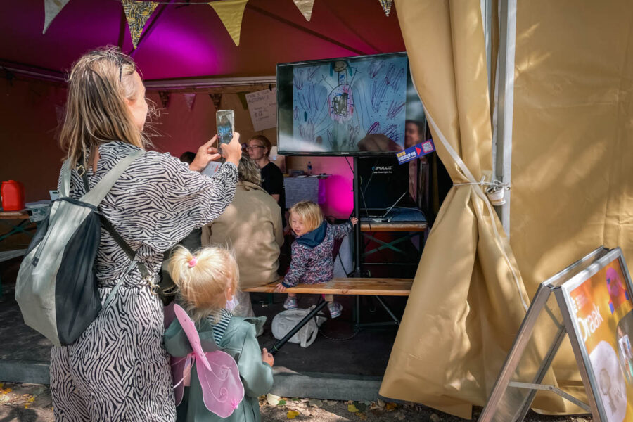 FS_Automaatje20 Kind bekijkt op een festival filmpje van zelf gemaakte mechanische automata die een figuur laat bewegen door techniek.