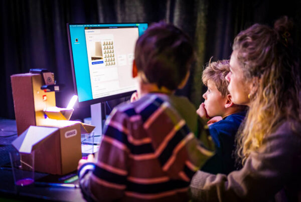 Ouder en kinderen die samenwerken om met machine learning een machine leert vormen te herkennen.