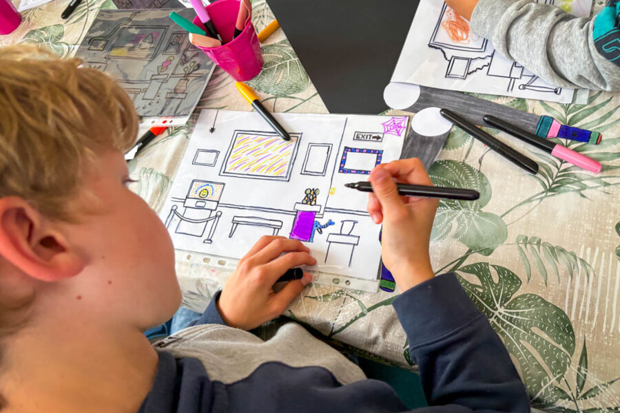 FS_SpotOn1 Leerling tekent zoekplaat die met een papieren zaklamp verborgen figuren en objecten onthult.